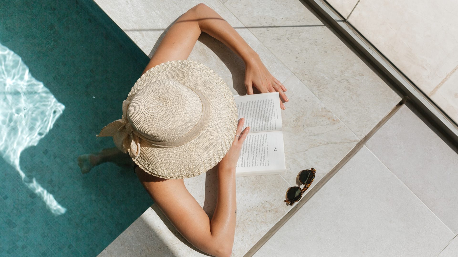 woman reading a book by the pool at The Legacy at Veramendi