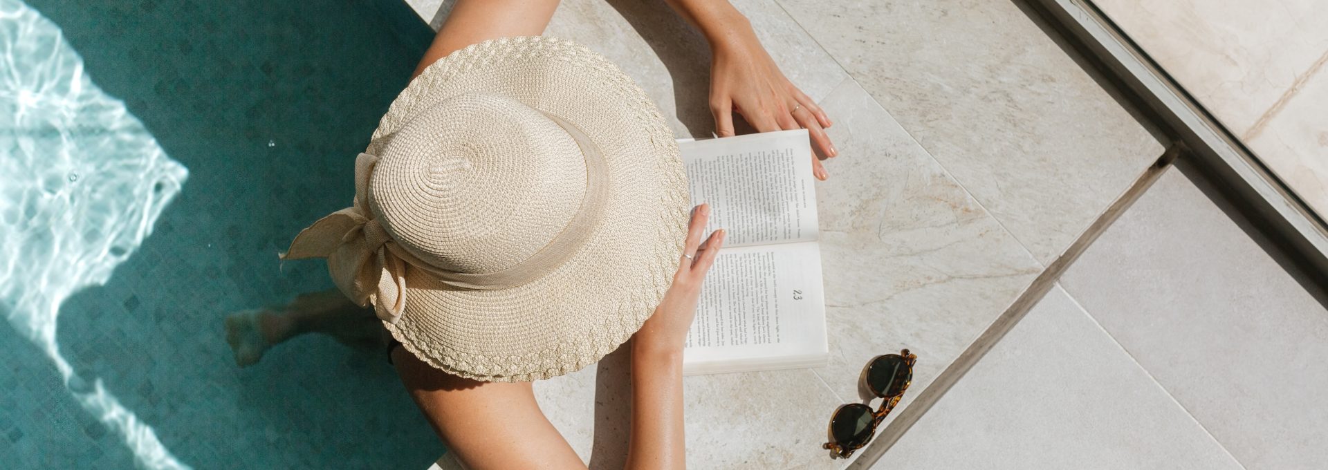 woman reading a book by the pool at The Legacy at Veramendi