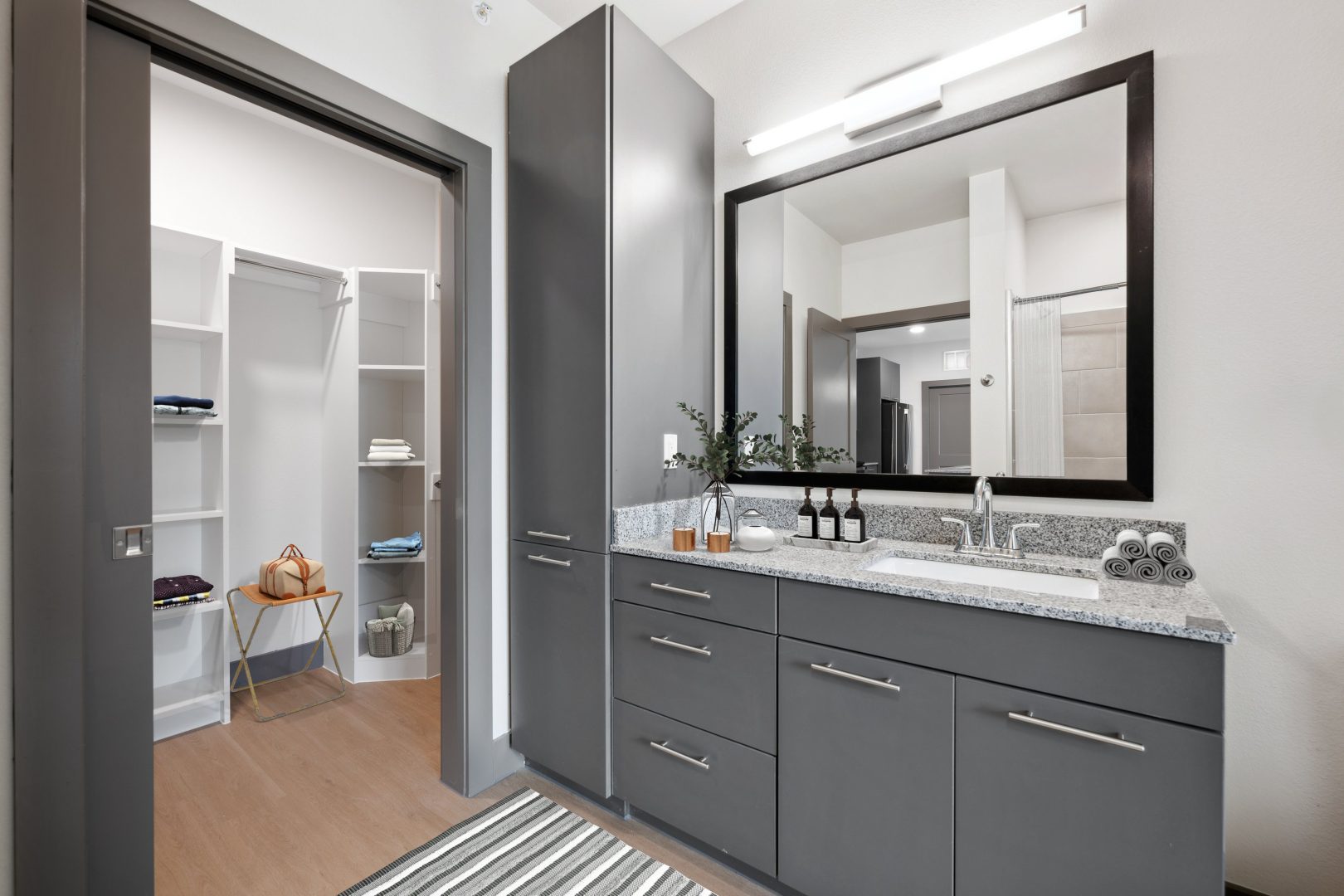 a bathroom with a large mirror and cabinets at The Legacy at Veramendi