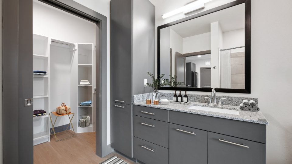 a bathroom with a large mirror and cabinets at The Legacy at Veramendi