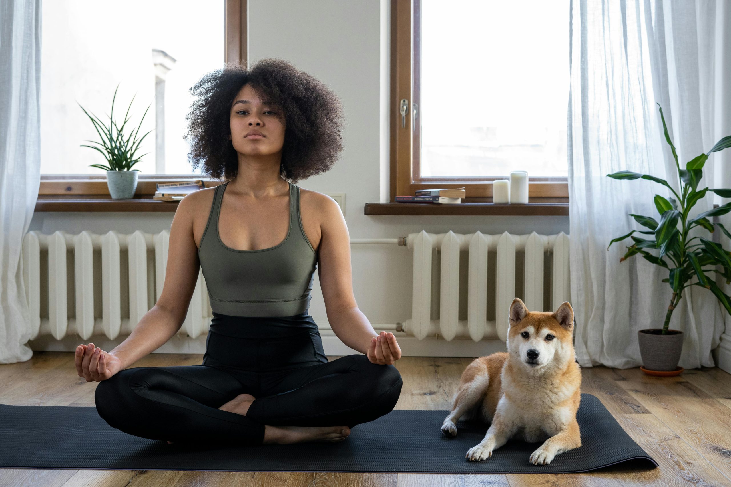 a woman sits on a yoga mat with her dog at The Legacy at Veramendi